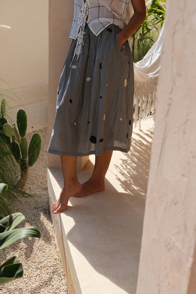 Introducing our All Dots Are Not Black Skirt, a collaboration between Audrey E Leary and World of Crow. This grey midi skirt showcases distinctive black and white polka dots on handwoven cotton, offering both comfort and style. Sustainably made, it's perfect for everyday wear.