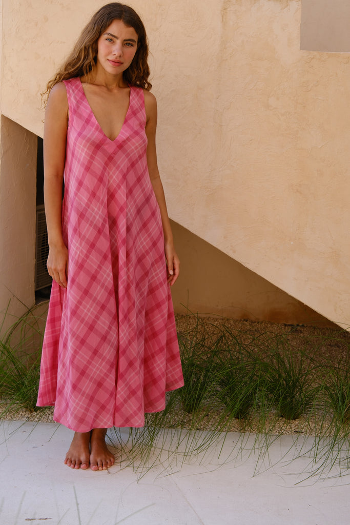 Introducing the Deep-Wine Checkered Midi Dress, a vintage-inspired creation from the collaboration between Audrey E Leary and World of Crow. This vintage-inspired dress features playful pink checks, a flattering V-neck, and a stylish midi length. Crafted from exceptionally light, hand-woven cotton, it offers a soft feel and excellent breathability for effortless everyday wear