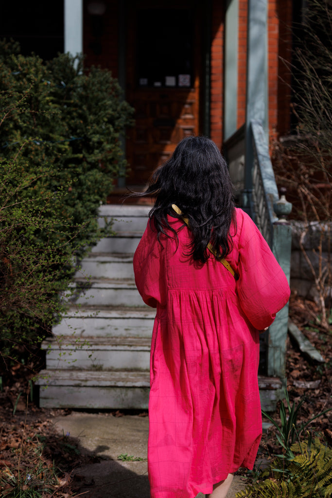 This Get Away Dress is made in a collaboration between Erica Kim @ahistoryofarchitecture and World of Crow, the dress has a scoop neck, barbie pink color, light checks in jamdani fabric