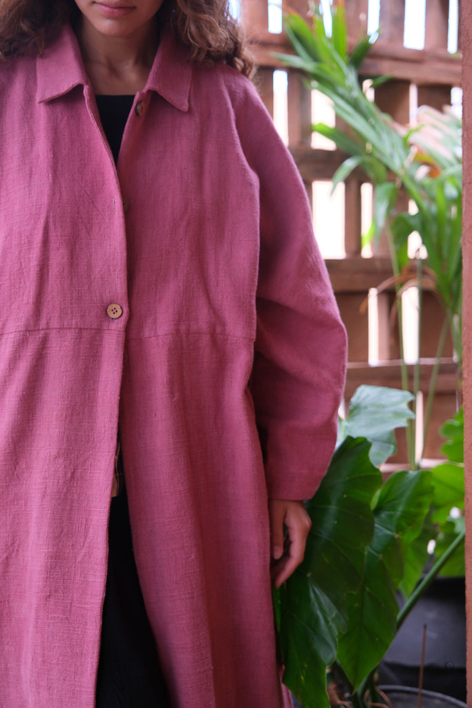 Introducing the Duster Jacket in a lovely pink shade, made from premium handwoven organic cotton in collaboration between Audrey E Leary and World of Crow. Featuring a straight collar, coconut buttons, and a relaxed fit with a straight hem, this versatile jacket offers a comfortable, midweight feel and fits true to size. Perfect for dressing up or adding sophistication to casual outfits.