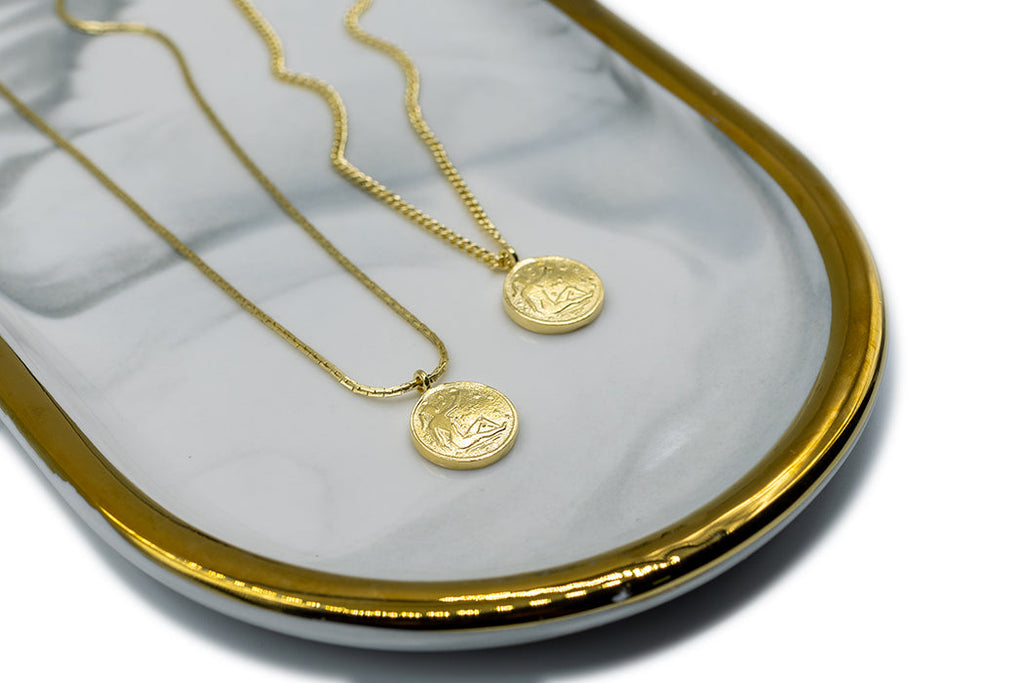 Introducing the Vintage Goddess Coin Necklace, featuring two coins on a 14K gold-plated curb chain. Made from recycled brass, this necklace combines timeless elegance with modern sustainability. Crafted in NYC and LA, it’s a luxurious yet eco-friendly addition to your collection.