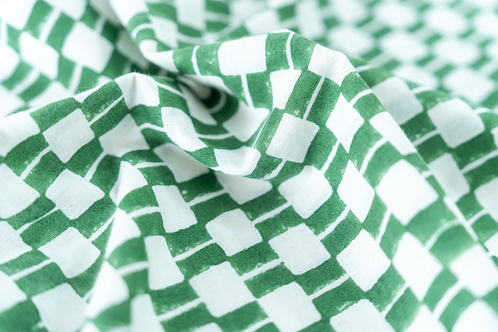 Detailed view of hand block printed fabric in green and white hue.
