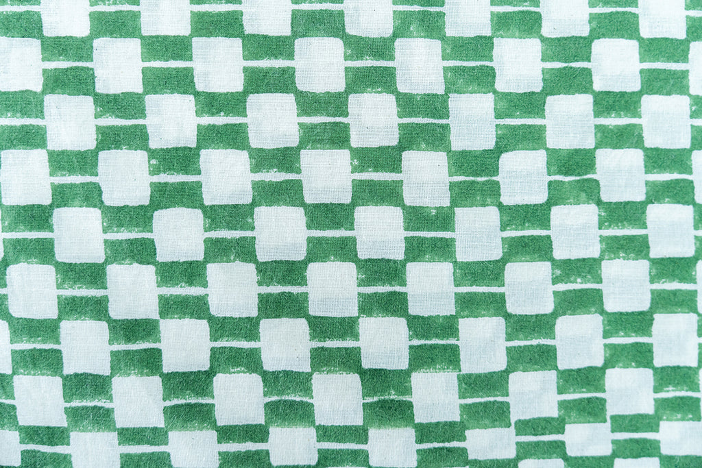 Detailed view of hand block printed fabric in green and white hue.