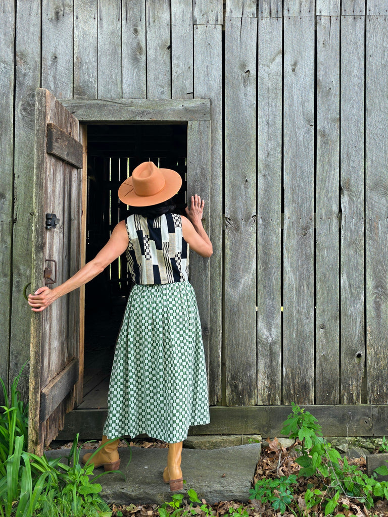 Green and white hand block-printed skirt made from 100% organic cotton, featuring a soft, lightweight fabric with azo-free dyes. Designed with a comfortable elasticated waist, full lining, and side pockets, this ethically made skirt falls 36” from the waist and fits true to size with a relaxed drape over the hips and legs. Each piece is uniquely handcrafted, with natural variations in color and pattern that reflect its artisanal charm—ideal for effortless, everyday wear.