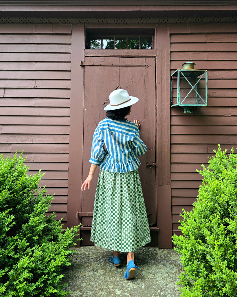 Green and white hand block-printed skirt made from 100% organic cotton, featuring a soft, lightweight fabric with azo-free dyes. Designed with a comfortable elasticated waist, full lining, and side pockets, this ethically made skirt falls 36” from the waist and fits true to size with a relaxed drape over the hips and legs. Each piece is uniquely handcrafted, with natural variations in color and pattern that reflect its artisanal charm—ideal for effortless, everyday wear.