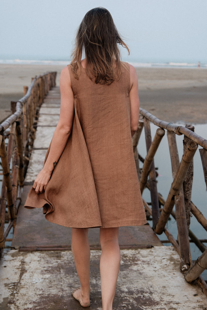 This noon dress is made in collaboration between Erica Kim and World of Crow, it has linen fabric, Brown rustic color, sleeveless, above knee-length dress, it is sustainably made and true to size
