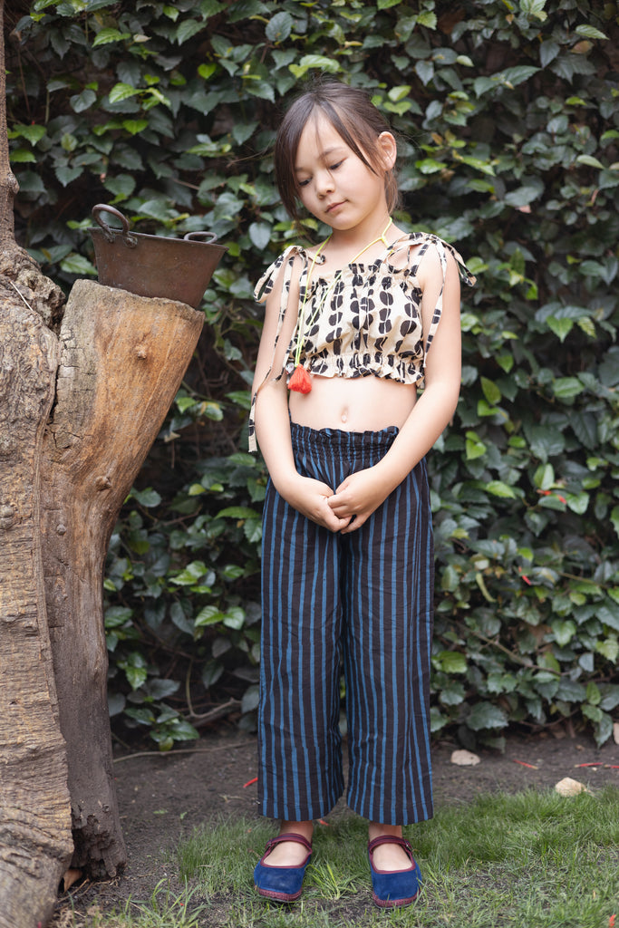 A pair of kids' wide-leg pants featuring vertical blue and black stripes. The pants have a high, elasticated waistband for a comfortable fit and a slightly cropped length, adding a relaxed and playful touch to the outfit.