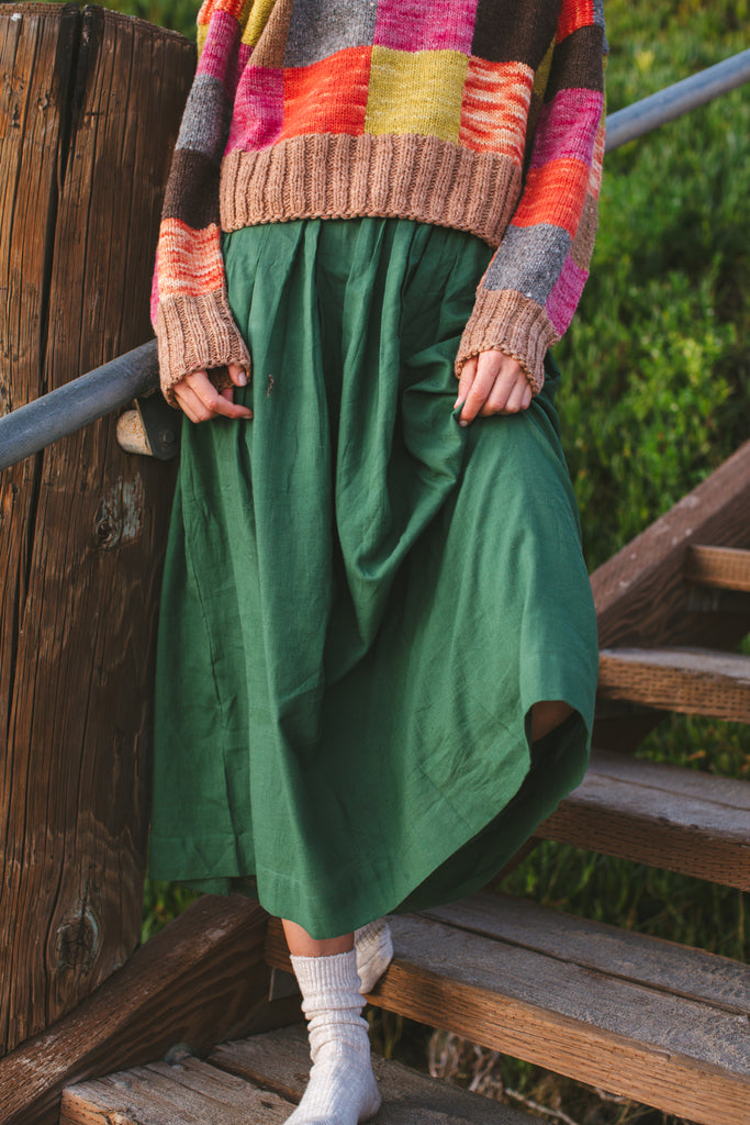 A Forest Green pull-on Skirt made from 100% handwoven cotton, this mid-rise skirt features an elasticated waistband and a straight mid-calf hem, offering a stylish and comfortable fit