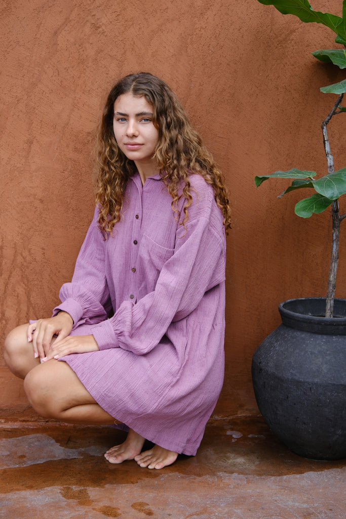 Introducing the Artist Smock, a collaboration between Audrey E Leary and World of Crow. This pink dual-tone smock is crafted from thick, handwoven organic cotton and features a straight collar, puff full sleeves, and spacious pockets. With a short length and gathered cuffs, it offers a comfortable fit and is perfect for painting, crafting, and staying cozy during travel.