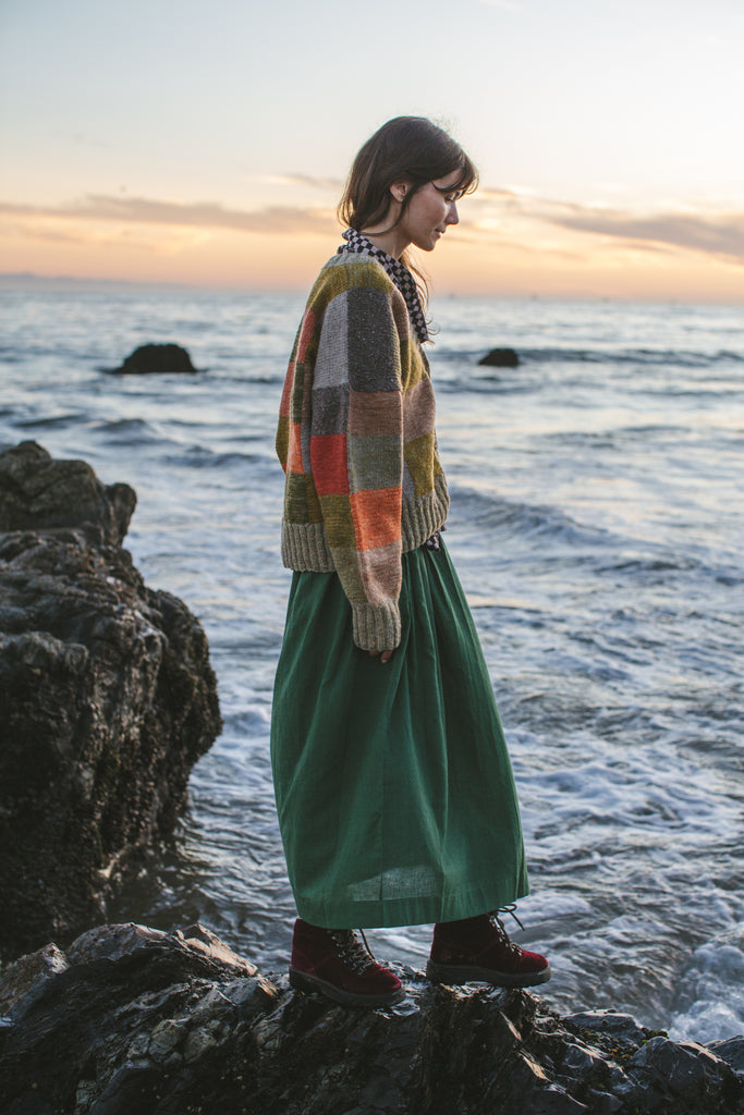 A Forest Green pull-on Skirt made from 100% handwoven cotton, this mid-rise skirt features an elasticated waistband and a straight mid-calf hem, offering a stylish and comfortable fit