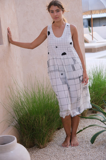 Introducing the Joan Check Dress, a collaboration between Audrey E Leary and World of Crow. This black and white midi-length dress features a refined mosaic pattern, a round V-neck, and is crafted from soft, handwoven cotton. Sustainably made with a relaxed fit and midweight fabric, it’s perfect for layering with the Artist Smock for a versatile look