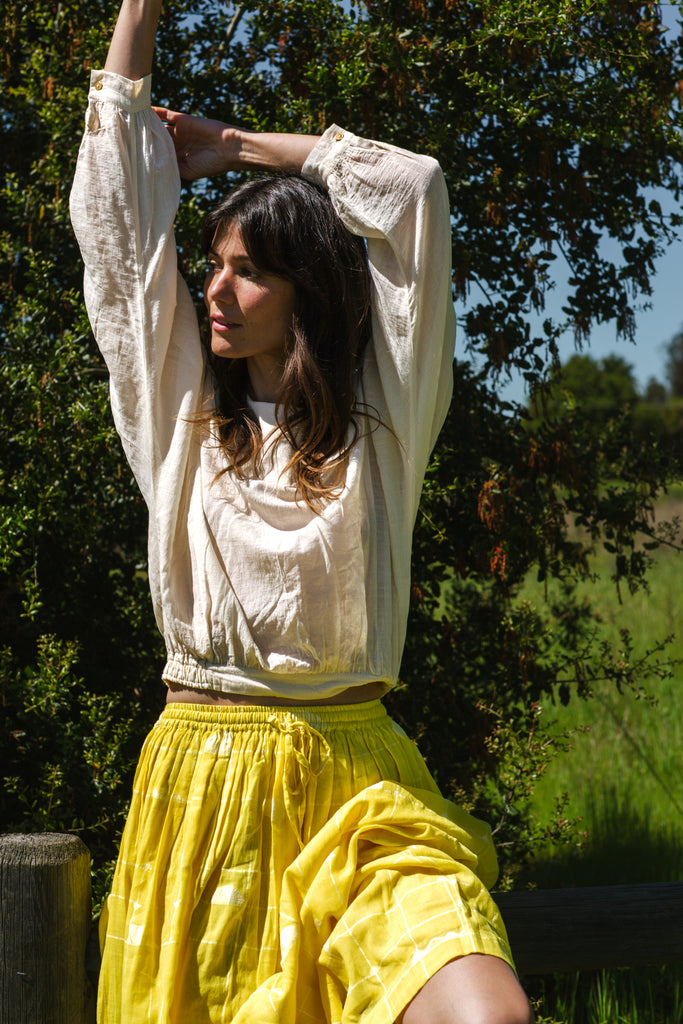 Introducing the Vintage Bertha Blouse, a timeless summer staple exuding effortless charm. Crafted from handwoven cotton in a serene off-white hue, it offers versatility and breathability for warmer days. Boasting a classic bertha collar, three-quarter sleeves, and a straight hem, this blouse epitomizes understated elegance. Pair it with any bottom for a stylish ensemble suitable for any occasion.