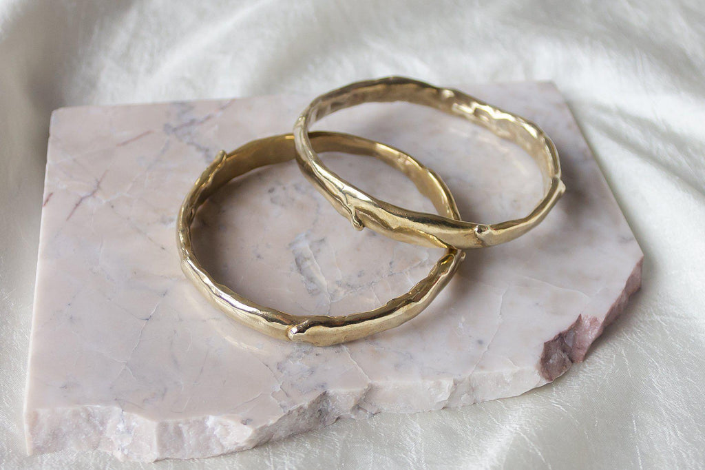 Introducing our handcrafted gold bangles, meticulously made in Downtown Los Angeles. Each bangle features a unique tactile texture and luxurious melted drips, creating an elegant and distinctive look. Perfectly combining craftsmanship with a touch of sophistication, these bangles are designed to elevate any ensemble.